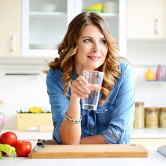 A woman drinking a glass of water.